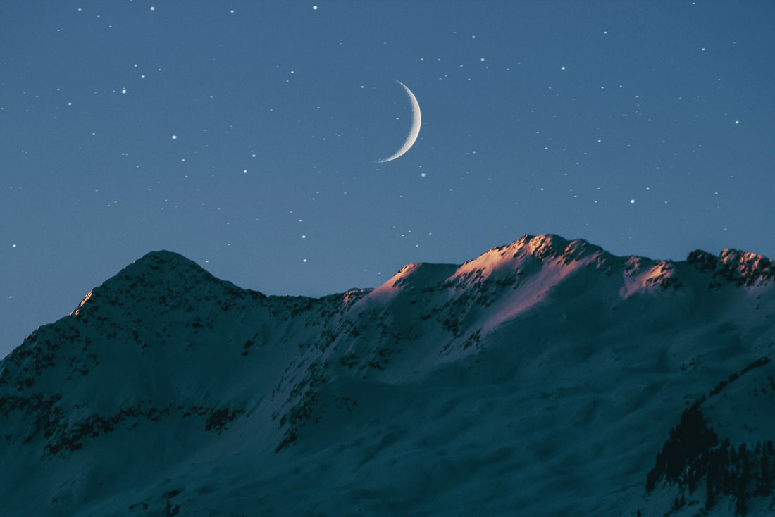 Hvordan bli trøtt? Bilde av et fjellandsskap med en måne over - blå-lilla farger